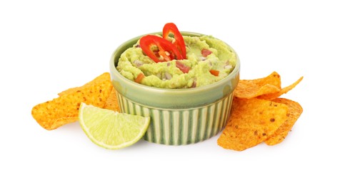 Photo of Bowl of delicious guacamole, lime and nachos chips isolated on white