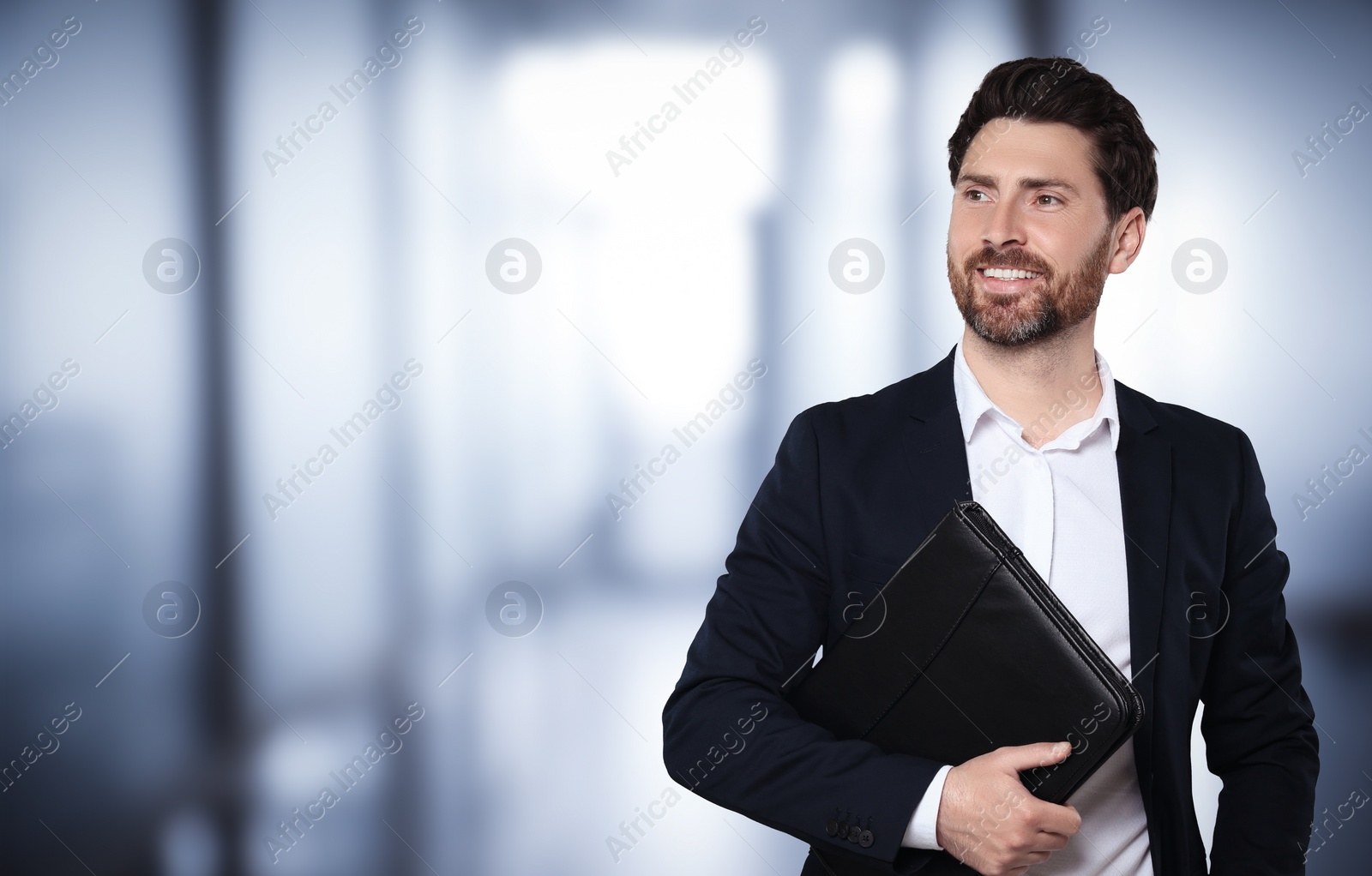 Image of Handsome real estate agent with portfolio in office, space for text