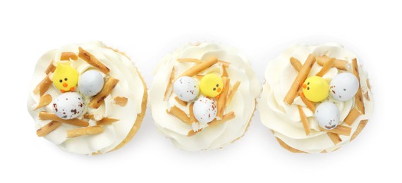 Photo of Tasty Easter cupcakes with vanilla cream isolated on white, top view