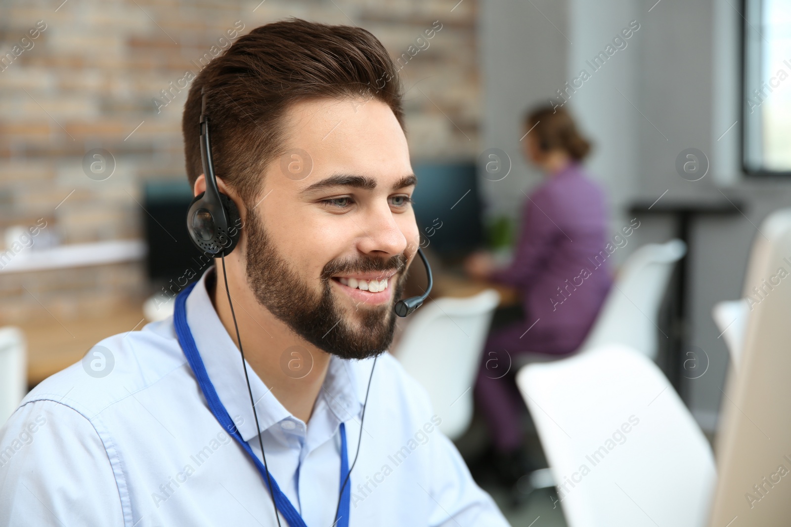 Photo of Technical support operator working with headset in office