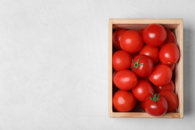 Photo of Wooden crate filled with fresh delicious tomatoes on table, top view. Space for text