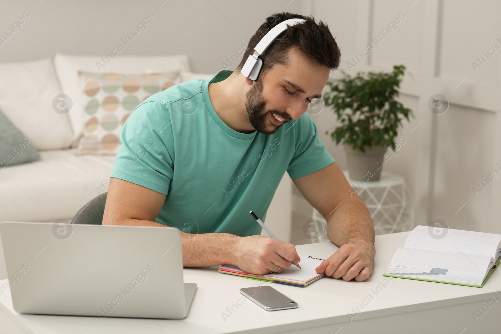 Photo of Online test. Man studying with laptop at home