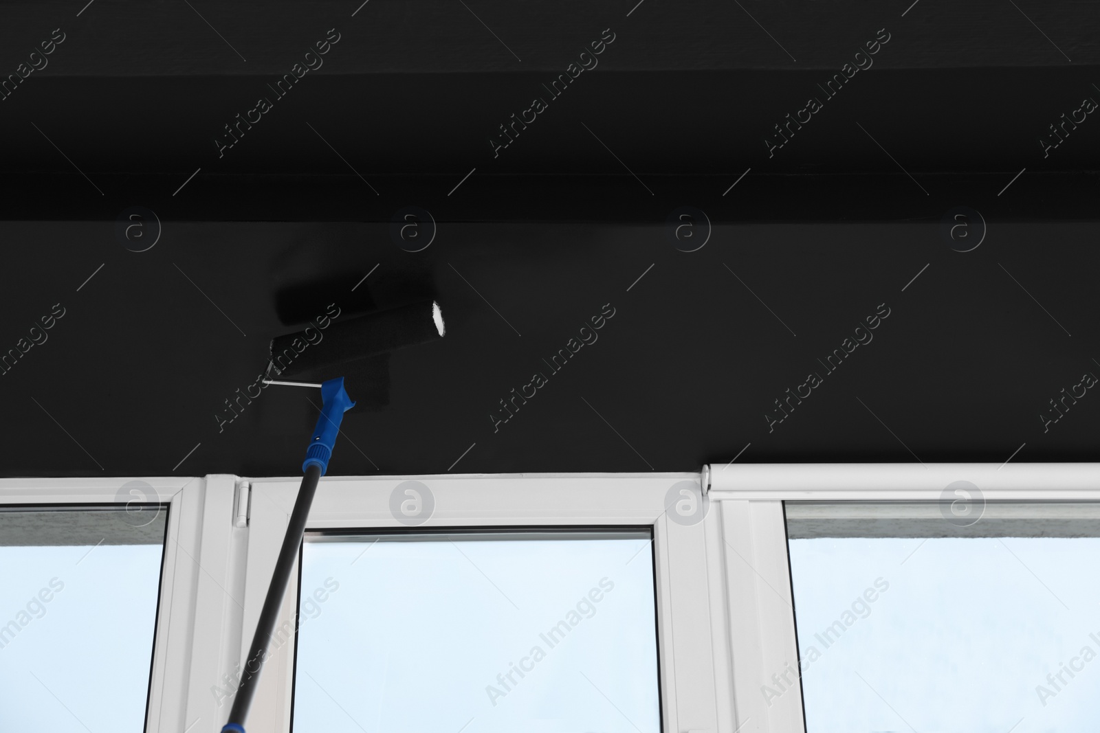Photo of Painting ceiling with black dye indoors, low angle view. Space for text