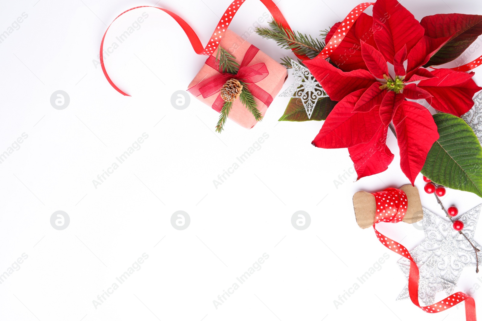 Photo of Flat lay composition with beautiful poinsettia and gift on white background, space for text. Christmas traditional flower