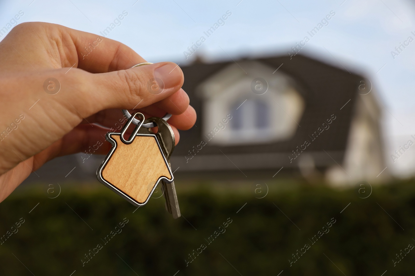 Photo of Woman holding house keys outdoors, closeup with space for text. Real estate agent