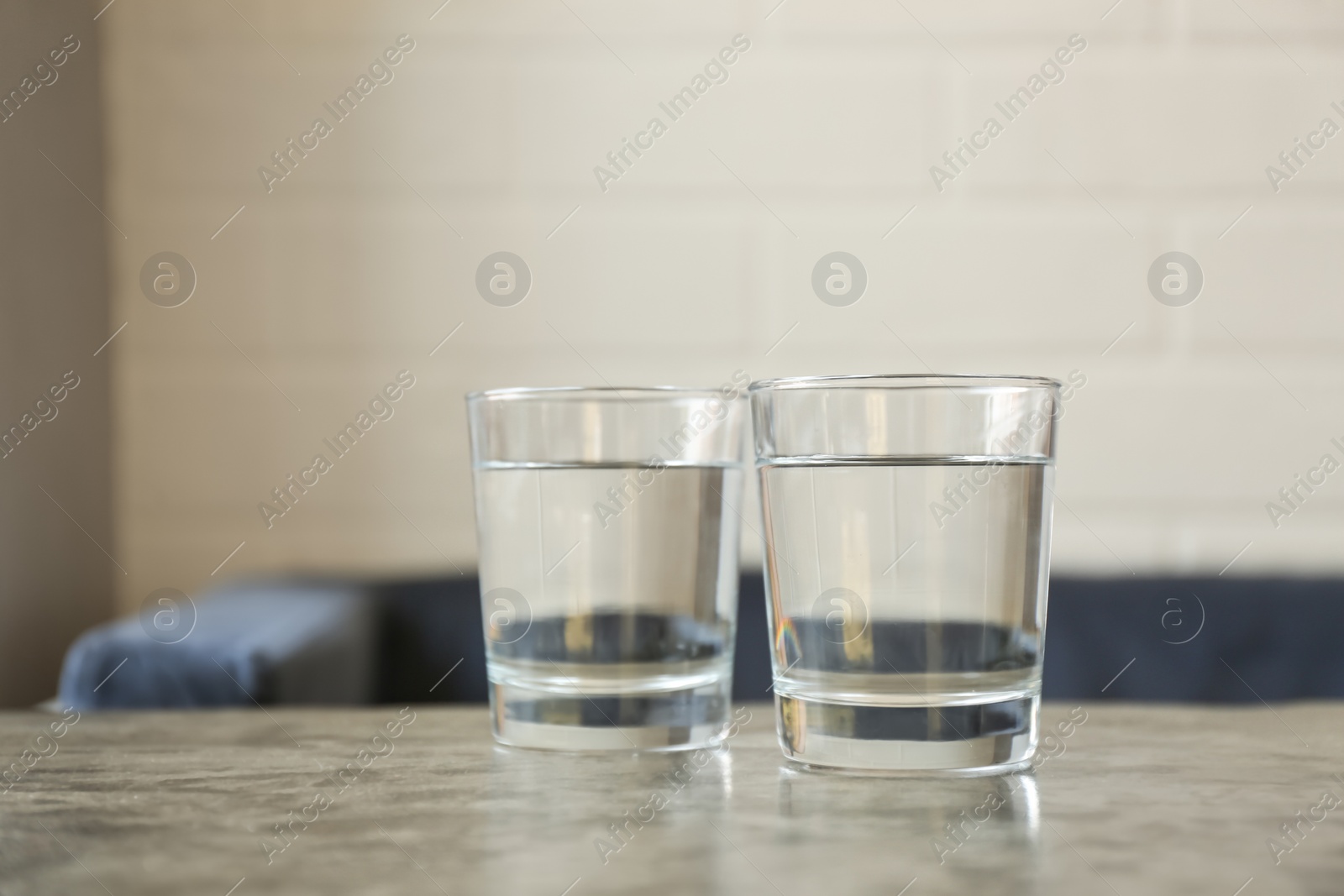 Photo of Glasses of water on grey table indoors