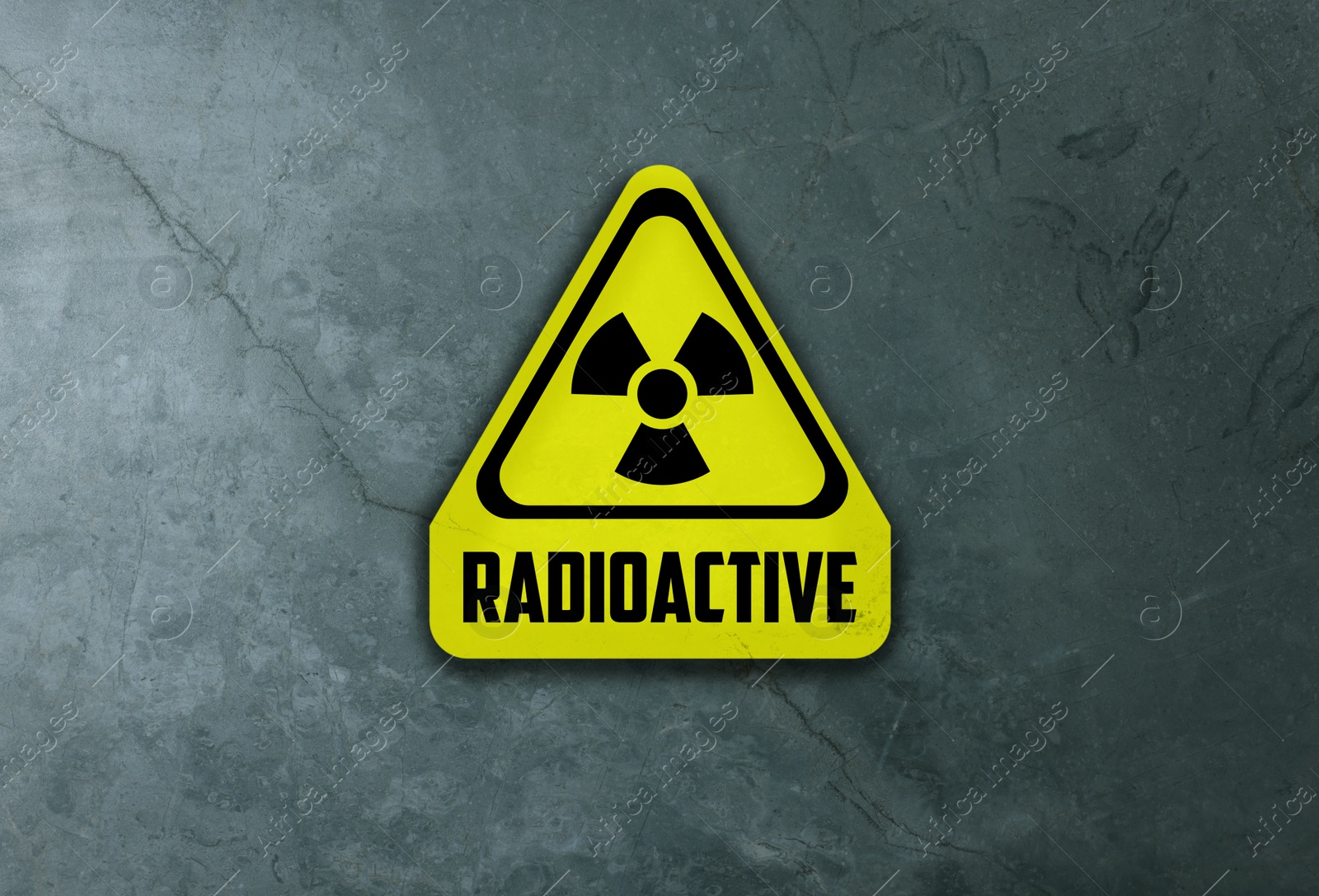 Image of Radioactive sign on grey stone wall. Hazard symbol