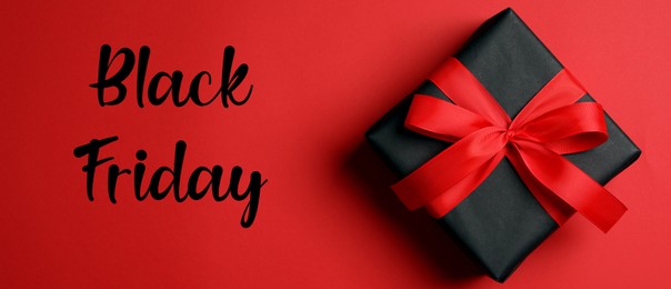 Image of Phrase Black Friday and gift box on red background, top view. Banner design