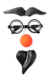 Photo of Funny face made with clown's accessories on white background, top view