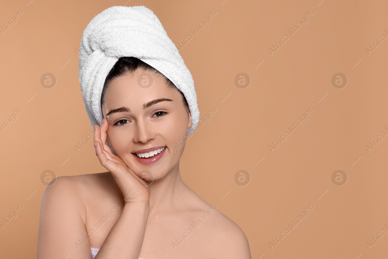 Photo of Portrait of attractive young woman with towel on beige background, space for text. Spa treatment