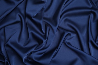 Crumpled dark blue silk fabric as background, top view