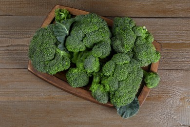 Tray with fresh raw broccoli on wooden table, top view