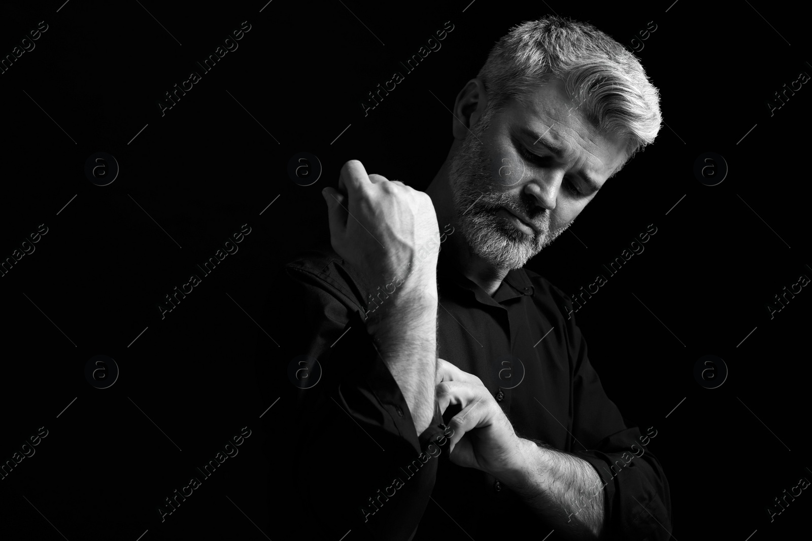 Photo of Portrait of handsome man on dark background. Black and white effect