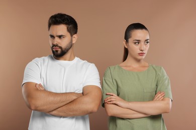 Photo of Resentful couple with crossed arms on brown background