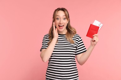 Happy young woman with passport and ticket on pink background