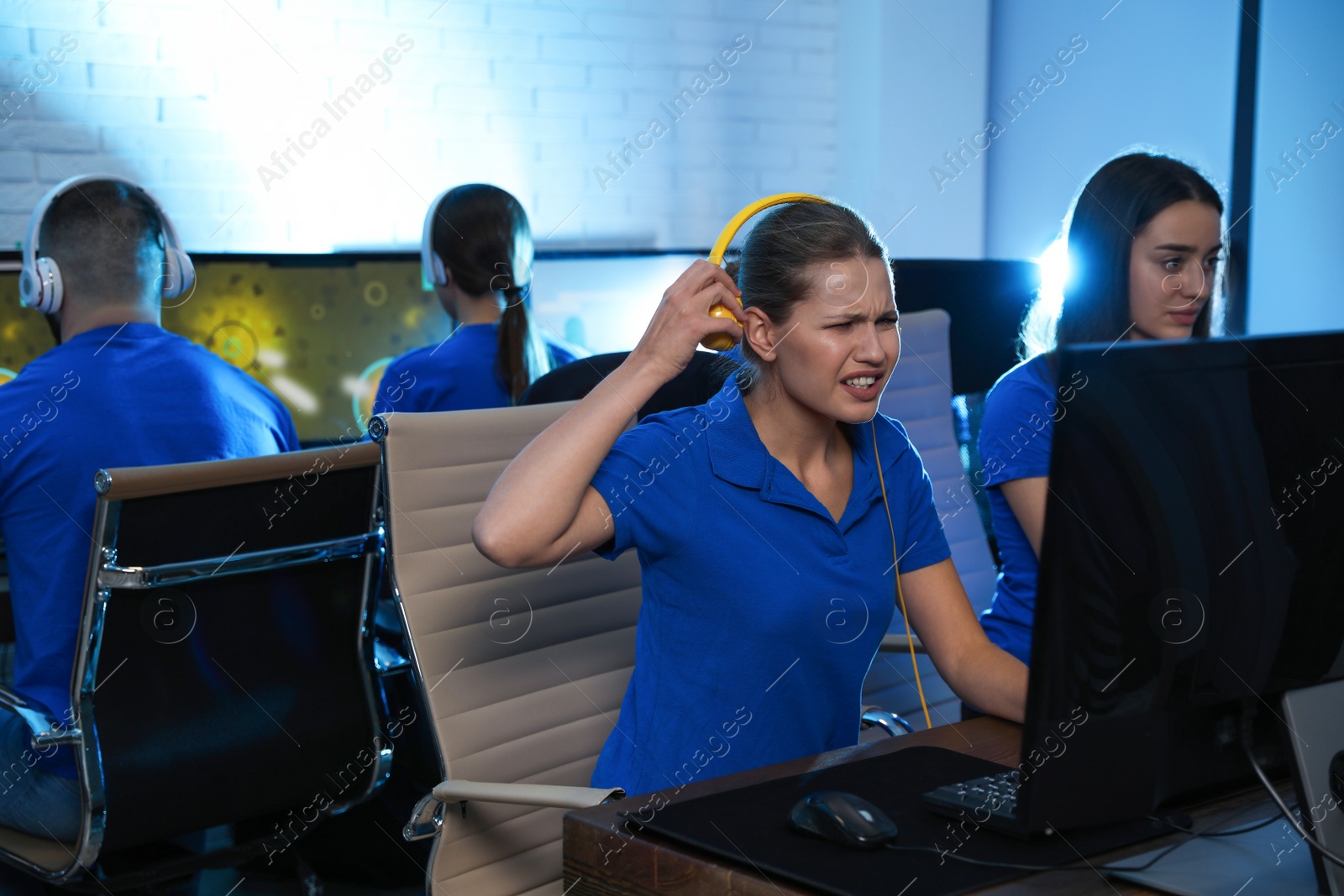 Photo of Young people playing video games on computers indoors. Esports tournament