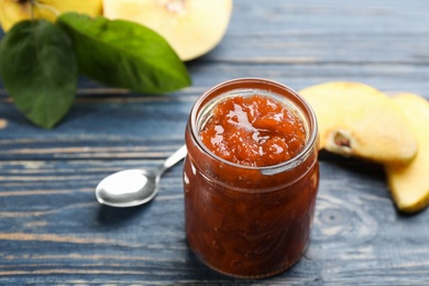 Delicious quince jam and fruits on blue wooden table