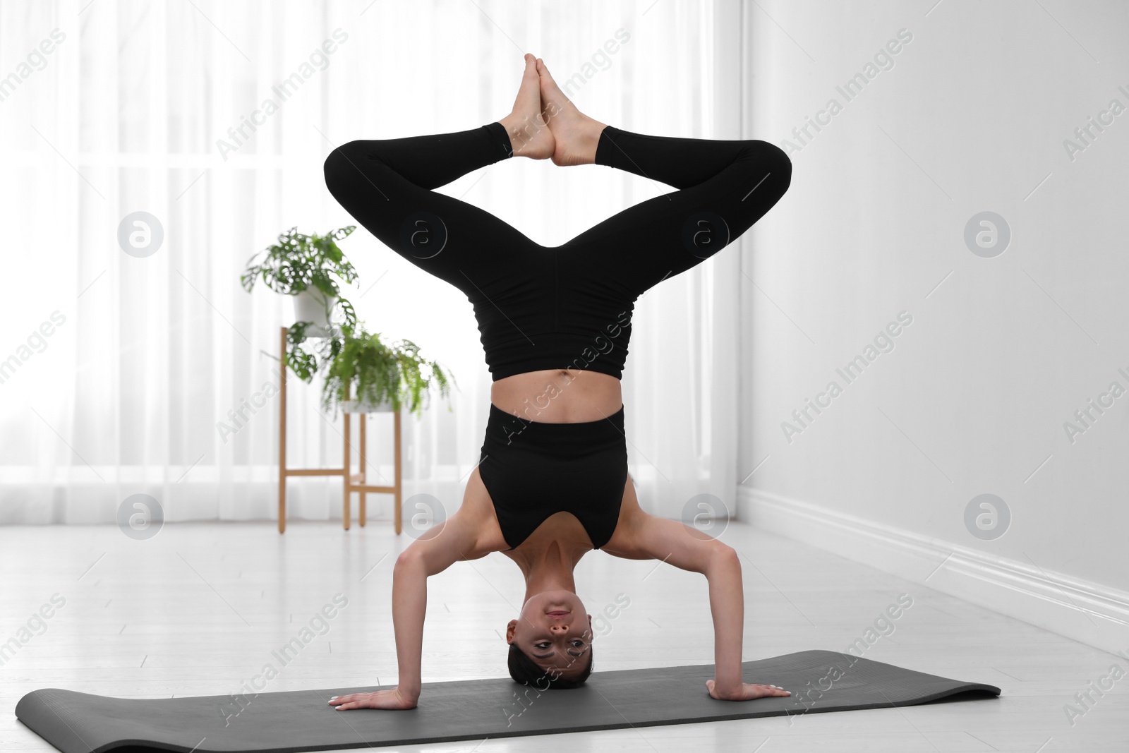 Photo of Professional young acrobat practicing yoga at home