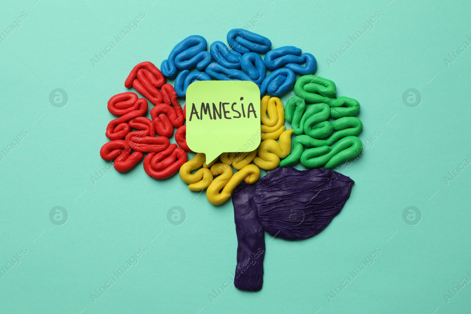 Photo of Human brain made of colorful plasticine and paper note with word Amnesia on turquoise background, flat lay