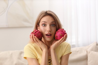 Young woman with fresh pitahayas at home. Exotic fruits