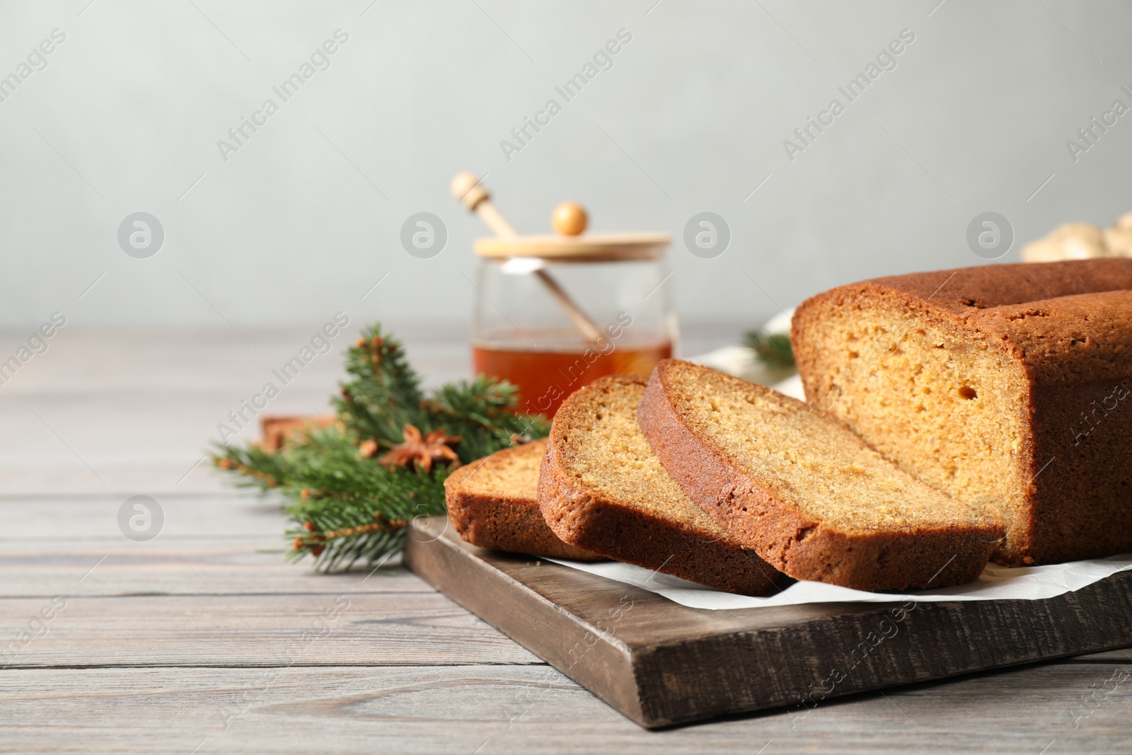 Photo of Fresh sliced gingerbread cake on wooden table, space for text