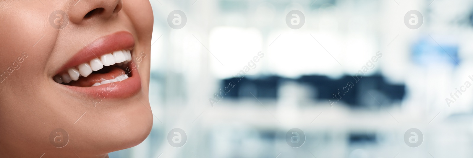 Image of Woman with clean teeth smiling on blurred background, closeup. Banner design with space for text