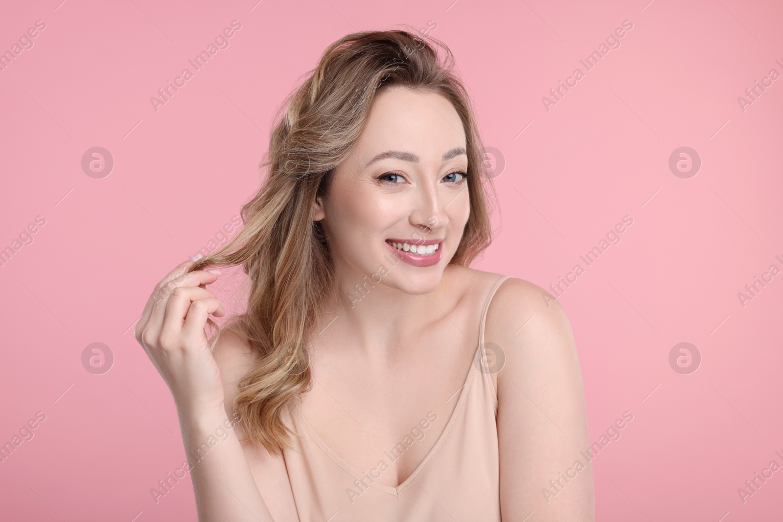 Photo of Portrait of smiling woman on pink background