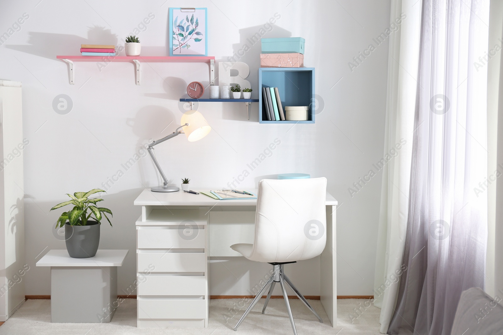 Photo of Stylish room interior with comfortable workplace near window. Design idea