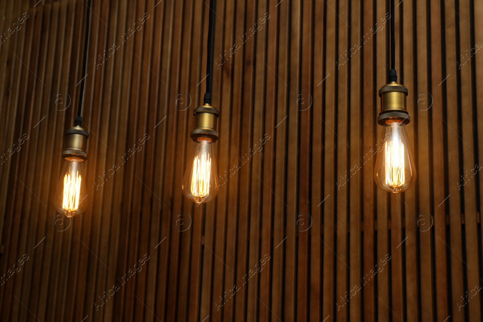 Photo of Pendant lamps with light bulbs on wooden background