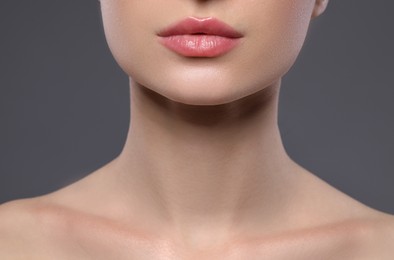 Photo of Young woman with beautiful lips on grey background, closeup