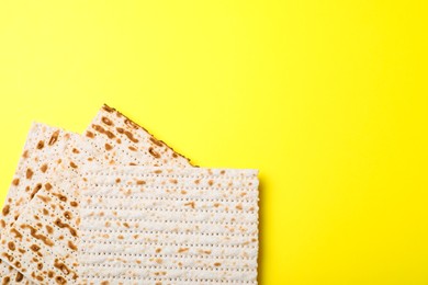 Photo of Traditional matzos on yellow background, flat lay. Space for text