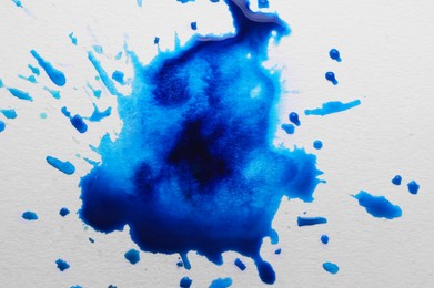 Blue ink blots on white canvas, top view