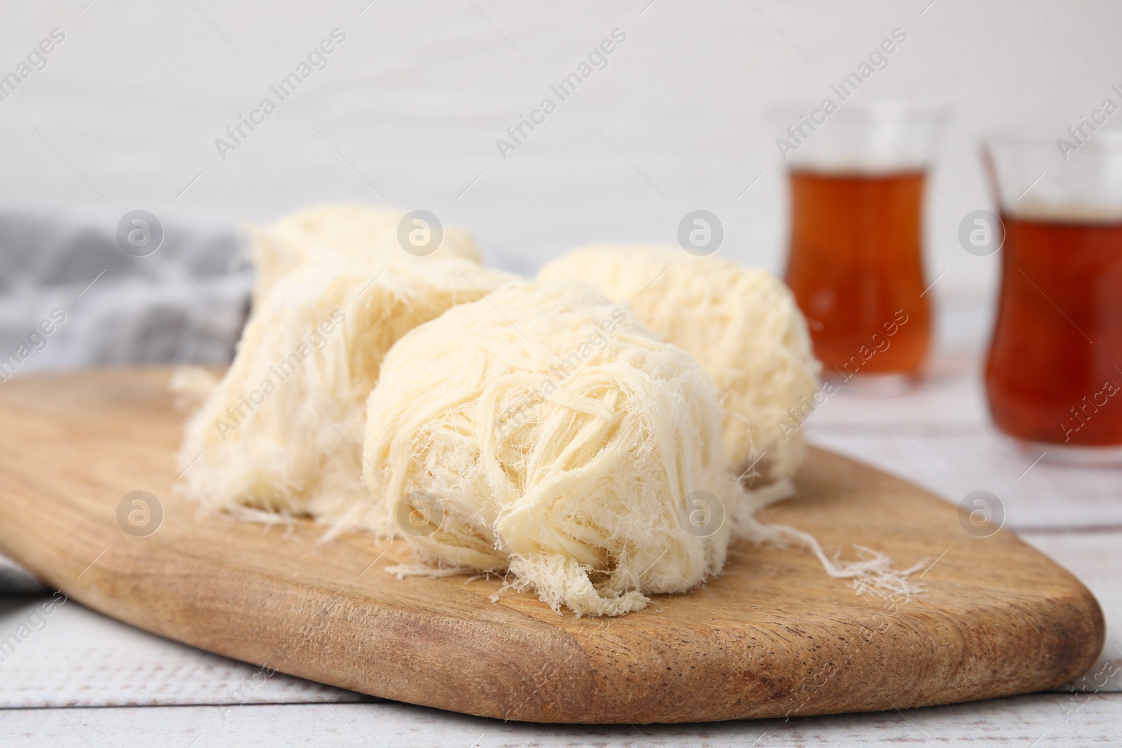 Photo of Eastern sweets. Tasty Iranian pashmak on white wooden table, closeup