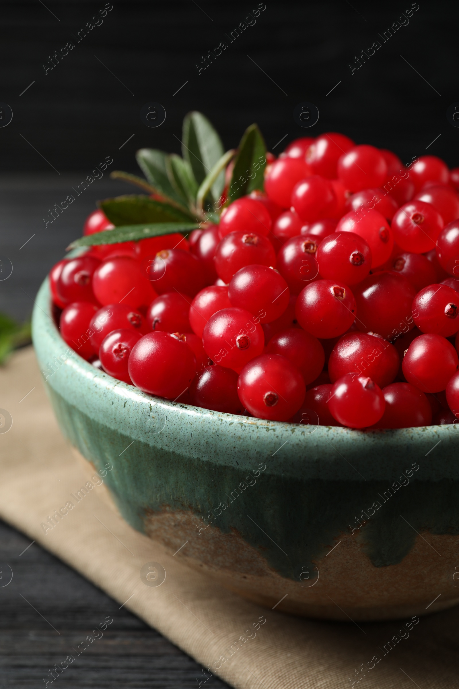 Photo of Tasty ripe cranberries on black table, closeup