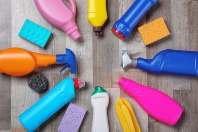 Photo of Flat lay composition with cleaning supplies on wooden background