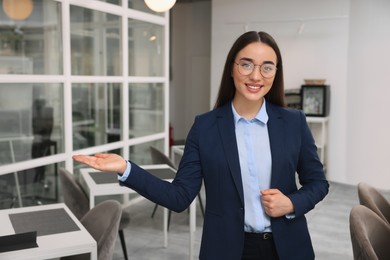 Happy female real estate agent in office