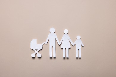 Photo of Paper family figures on beige background, top view. Insurance concept