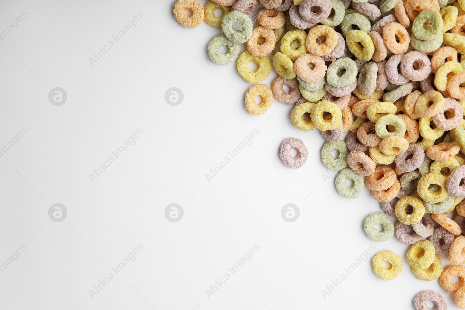 Photo of Tasty cereal rings on white background, flat lay. Space for text