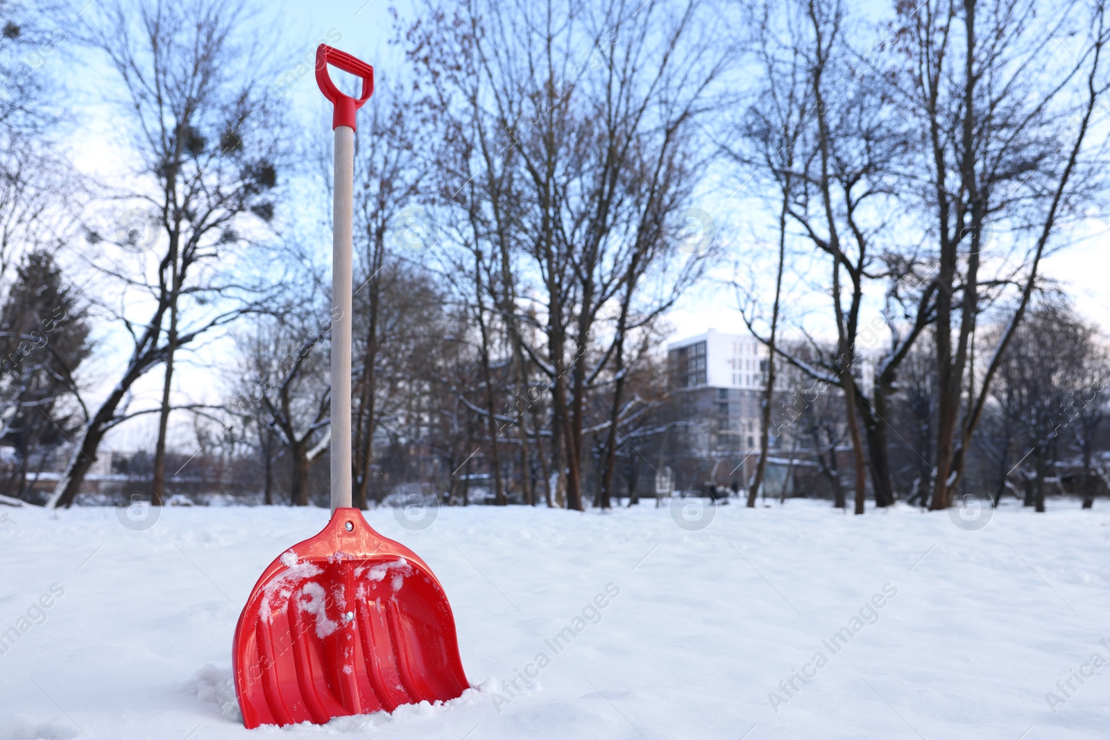 Photo of Snow shovel with wooden handle outdoors. Space for text