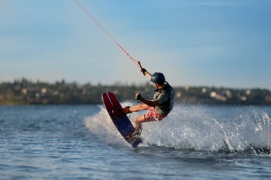 Teenage boy wakeboarding on river. Extreme water sport