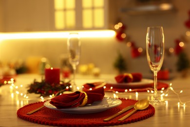 Photo of Christmas table setting with festive decor in kitchen