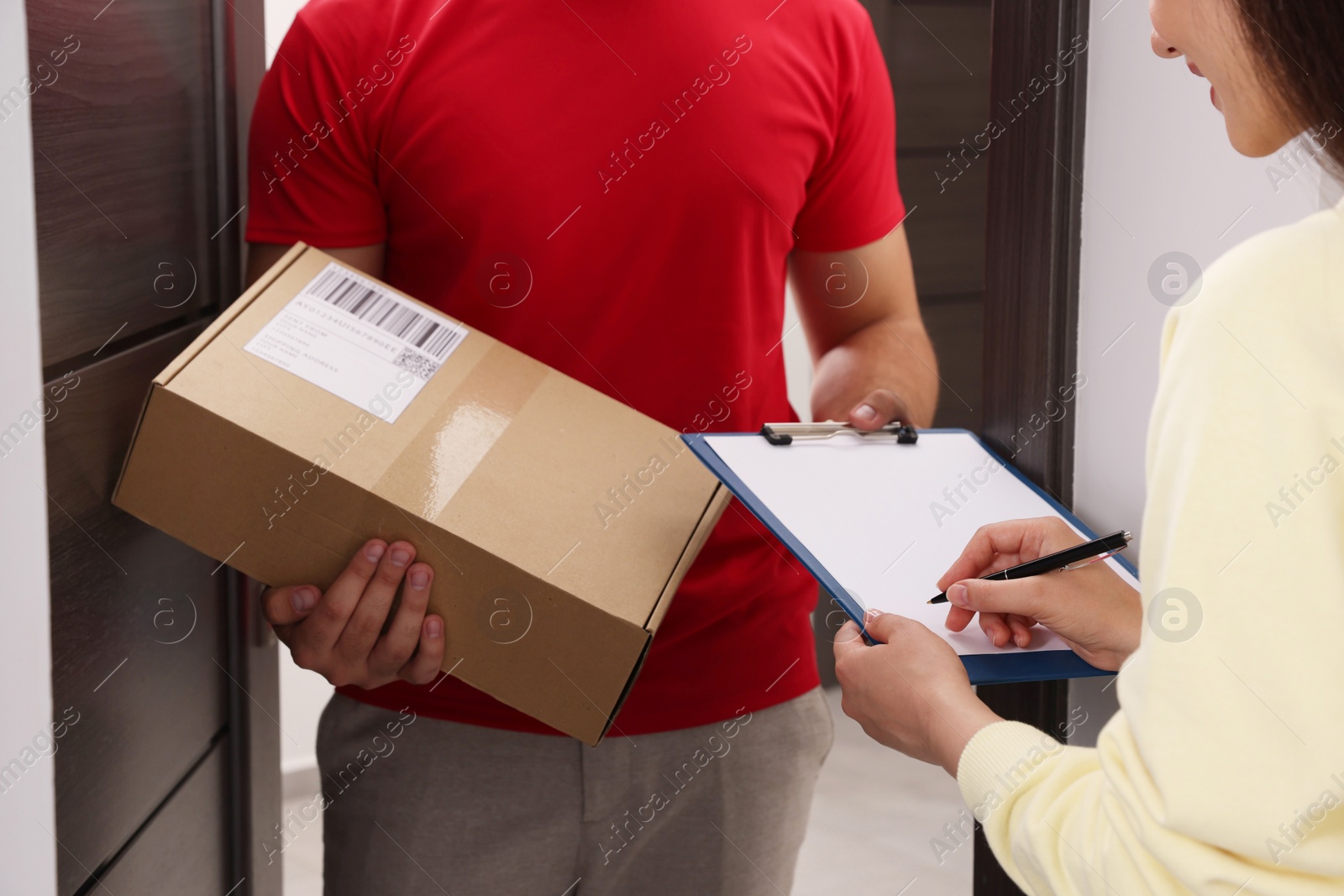 Photo of Woman signing for delivered parcel at home, closeup