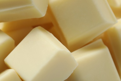 Pieces of delicious white chocolate as background, closeup