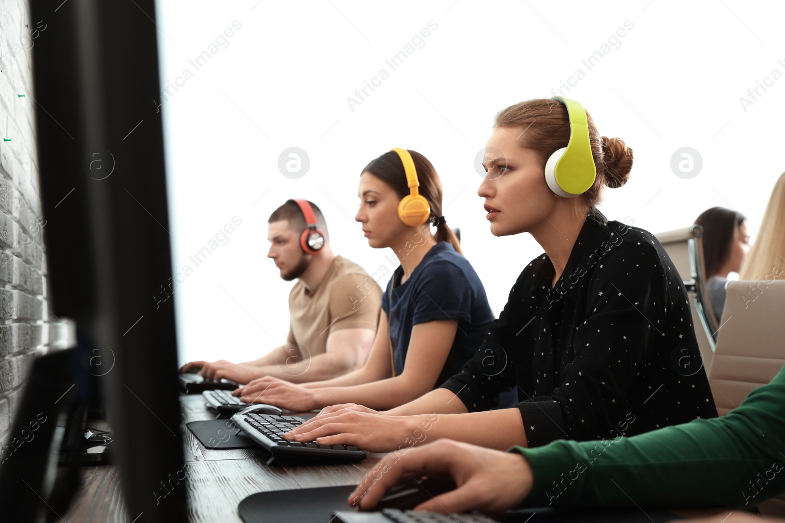 Photo of Young people playing video games on computers indoors. Esports tournament