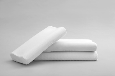 Clean soft orthopedic pillows on grey background