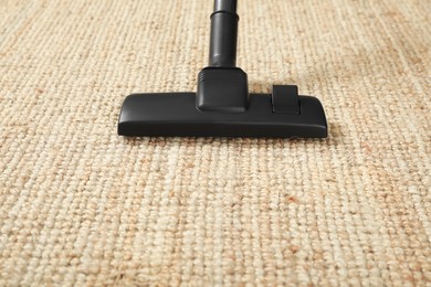 Photo of Removing dirt from beige carpet with modern vacuum cleaner. Space for text