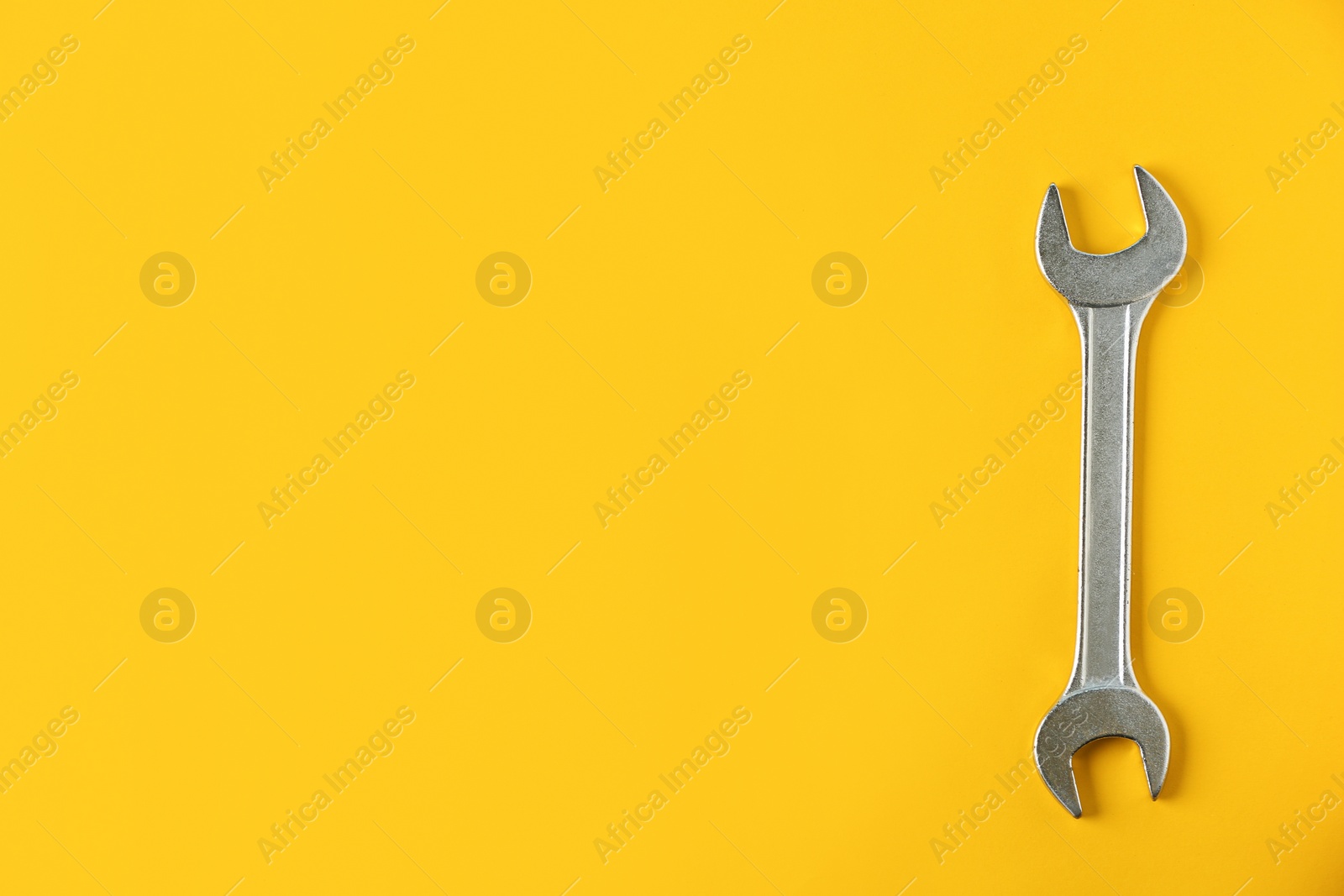 Photo of New wrench on color background, top view with space for text. Plumber tools