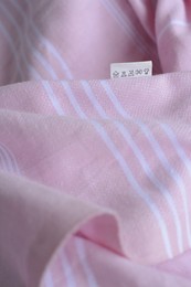 White clothing label on pale pink garment