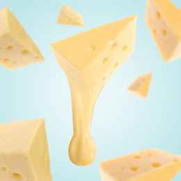 Image of Pieces of cheese falling on light blue background