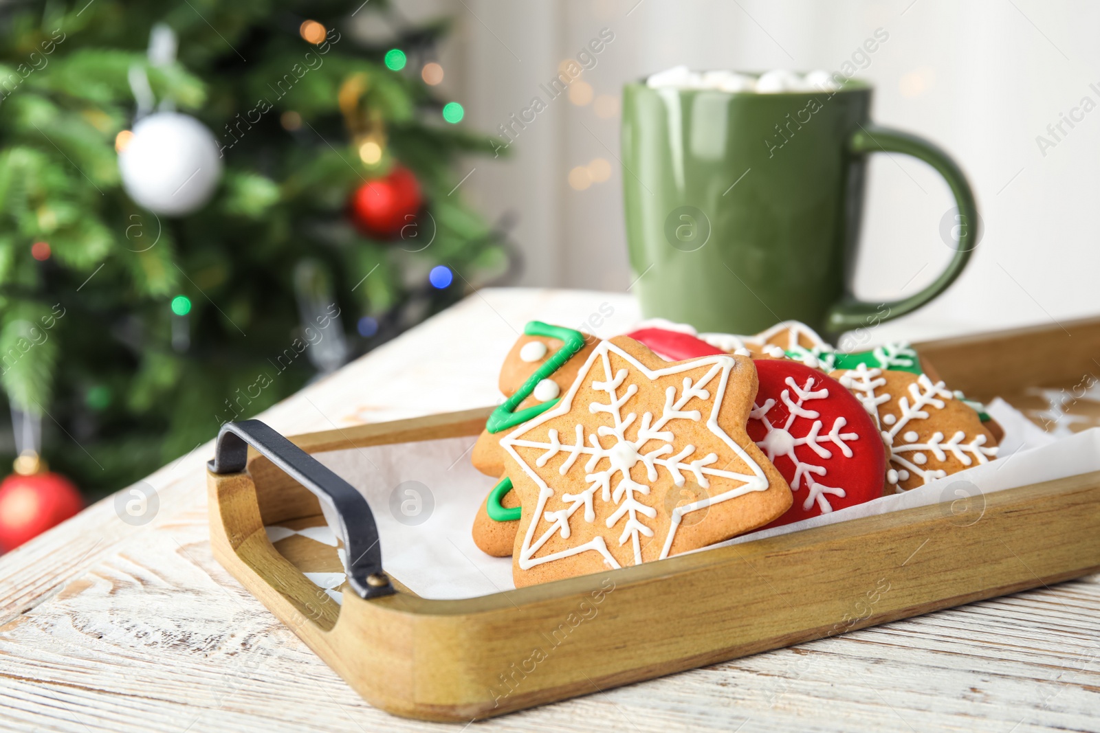 Photo of Tray with tasty homemade Christmas cookies and cup of cacao on table